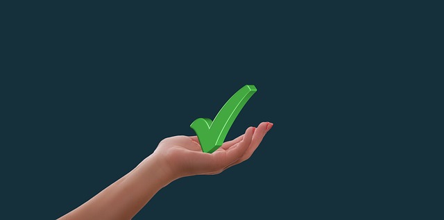 Hand holding a green tick arrow